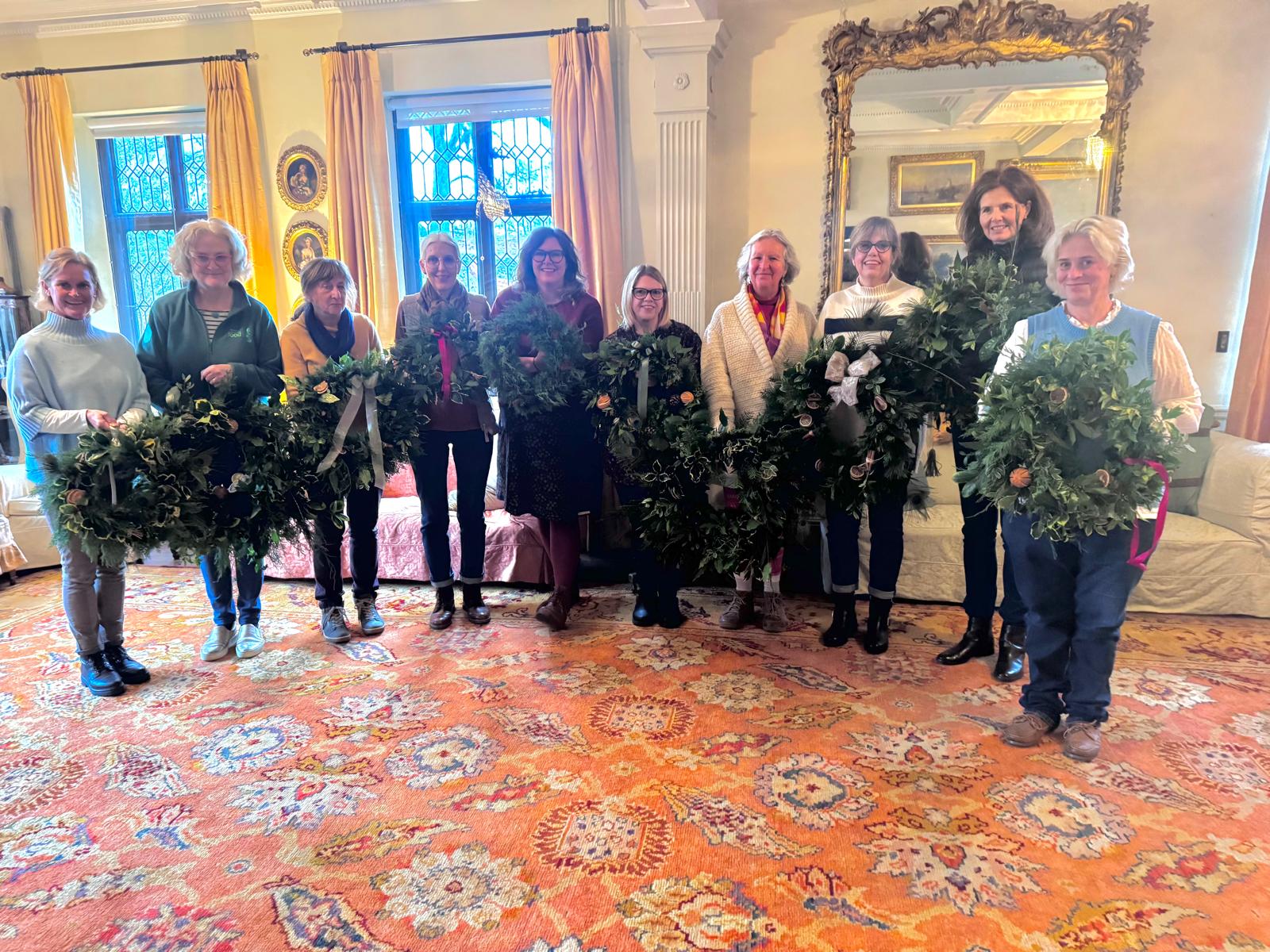 Group photo of participants holding their wreaths they have made